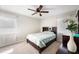 Inviting bedroom with neutral walls, carpet, a wooden bed frame, a ceiling fan, and natural light from two windows at 1948 Oakland Park Dr, Lake Wales, FL 33898