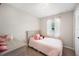 Charming small bedroom with a twin bed, soft pink accents, natural light, and a playful atmosphere at 1948 Oakland Park Dr, Lake Wales, FL 33898