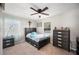 A tidy bedroom with a neutral color scheme, featuring a bed, side tables, a dresser, and bright windows at 1948 Oakland Park Dr, Lake Wales, FL 33898