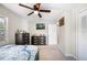 Cozy bedroom featuring a large dresser, a ceiling fan, and natural light from a bright window at 1948 Oakland Park Dr, Lake Wales, FL 33898