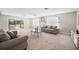 Bright, carpeted living room featuring neutral tones, comfortable seating, and natural light from large windows at 1948 Oakland Park Dr, Lake Wales, FL 33898