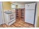 White appliances and light-toned built-in bookshelves complement the wood-look laminate flooring in this kitchen at 200 Spurlock Rd, Frostproof, FL 33843
