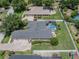 An aerial view displays a home with a pool, neatly manicured landscaping, and surrounding greenery at 2026 Indian Sky Cir, Lakeland, FL 33813