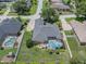 Aerial view showcasing a house with a pool, manicured lawn, and the surrounding neighborhood at 2026 Indian Sky Cir, Lakeland, FL 33813