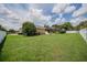 Expansive backyard with lush green grass, a screened-in pool area, and privacy fencing at 2026 Indian Sky Cir, Lakeland, FL 33813