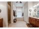 Well-lit bathroom features a shower, soaking tub, dual vanity sinks, and neutral tile flooring at 2026 Indian Sky Cir, Lakeland, FL 33813
