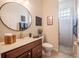 A well-lit bathroom features a round mirror and a clear glass shower at 2026 Indian Sky Cir, Lakeland, FL 33813
