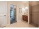 Neutral bathroom featuring a shower, single vanity sink, doorway view of the bedroom and walk-in closet at 2026 Indian Sky Cir, Lakeland, FL 33813