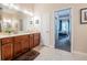 A large mirror reflects plenty of light into this spacious bathroom with beautiful cherry cabinets at 2026 Indian Sky Cir, Lakeland, FL 33813