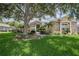 Charming single Gathering home featuring a lush lawn, mature shade trees, and an inviting stone and stucco exterior at 2026 Indian Sky Cir, Lakeland, FL 33813