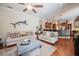 Inviting living room features hardwood floors, a ceiling fan, and an open layout connected to the kitchen at 2026 Indian Sky Cir, Lakeland, FL 33813