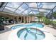 Inviting screened-in pool with a hot tub, sun loungers, and well-maintained landscaping at 2026 Indian Sky Cir, Lakeland, FL 33813