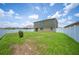 Expansive backyard featuring green grass, a small bush, and a white privacy fence, ensuring a serene outdoor space at 2062 Blue Highlands Dr, Lakeland, FL 33811