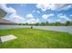 Wide shot of an empty, green backyard with a white fence and clear sky at 2062 Blue Highlands Dr, Lakeland, FL 33811