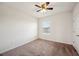 Bright bedroom features neutral carpet, ceiling fan, and window letting in natural light at 2062 Blue Highlands Dr, Lakeland, FL 33811