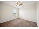 An empty bedroom features a window bringing in light, neutral paint and tan carpet flooring at 2062 Blue Highlands Dr, Lakeland, FL 33811