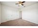 A carpeted bedroom with a ceiling fan, neutral colored walls, and multiple closets at 2062 Blue Highlands Dr, Lakeland, FL 33811
