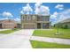 Charming two-story home with a well-manicured lawn, neutral exterior, and two-car garage at 2062 Blue Highlands Dr, Lakeland, FL 33811