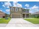 Charming two-story home with a well-manicured lawn, neutral exterior, and two-car garage at 2062 Blue Highlands Dr, Lakeland, FL 33811