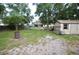 Large backyard with a shed and some mature trees, in need of landscaping at 240 Lake Thomas Dr, Winter Haven, FL 33880