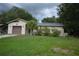 Single story home with attached garage, small palm tree and green lawn at 240 Lake Thomas Dr, Winter Haven, FL 33880