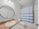 Functional bathroom with a vanity, toilet, and shower with a blue and white striped curtain at 2544 Ladoga Dr, Lakeland, FL 33805