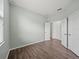 Minimalist bedroom with neutral walls, laminate flooring, bright window, and several entry doors at 2544 Ladoga Dr, Lakeland, FL 33805