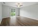 Bright bedroom features hardwood floors and sliding glass doors to the backyard at 2544 Ladoga Dr, Lakeland, FL 33805