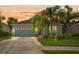 Charming single-story home with a well-maintained lawn and mature palm trees at sunset at 2544 Ladoga Dr, Lakeland, FL 33805