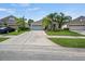Single-story home with a two-car garage, well-manicured lawn, and palm trees at 2544 Ladoga Dr, Lakeland, FL 33805