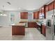 Modern kitchen featuring cherry-stained cabinets, granite countertops, stainless steel appliances, and a center island at 2544 Ladoga Dr, Lakeland, FL 33805