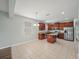 Open kitchen and dining space featuring stainless appliances, granite counters, cherry cabinets, and tiled floors at 2544 Ladoga Dr, Lakeland, FL 33805