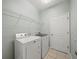 Functional laundry room featuring a modern washer, dryer, wire shelving, and tiled floors at 2544 Ladoga Dr, Lakeland, FL 33805