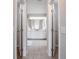 Bathroom hallway with double doors, offering a glimpse of the vanity, mirror, and tiled floors in a clean design at 2714 Highlands Vue Pkwy, Lakeland, FL 33813