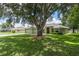 Beautiful home nestled under a large tree, featuring a well-kept lawn and a welcoming facade at 2714 Highlands Vue Pkwy, Lakeland, FL 33813