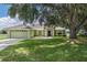 Charming single-story home boasts a well-maintained lawn, mature shade tree, and a welcoming two-car garage at 2714 Highlands Vue Pkwy, Lakeland, FL 33813