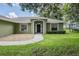 This home's façade includes a manicured lawn, minimalist landscaping, and an inviting front entryway at 2714 Highlands Vue Pkwy, Lakeland, FL 33813