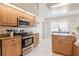 Sunlit kitchen with stainless steel appliances, light wood cabinets, granite countertops, and a view to the breakfast nook at 2714 Highlands Vue Pkwy, Lakeland, FL 33813