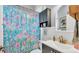Well-lit bathroom featuring vanity, toilet, and shower with patterned shower curtain at 2817 High Winds Ln, Lakeland, FL 33813