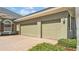 A spacious three-car garage with a brick-paved driveway and neatly trimmed landscaping at 2817 High Winds Ln, Lakeland, FL 33813
