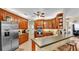 Spacious kitchen featuring wood cabinets, stainless steel refrigerator, and breakfast bar at 2817 High Winds Ln, Lakeland, FL 33813