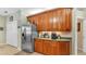 Kitchen features wood cabinets, stainless steel refrigerator, coffee bar, and tile flooring at 2817 High Winds Ln, Lakeland, FL 33813
