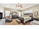 Spacious bedroom with tray ceiling, ceiling fan, sitting area, and large dresser with mirror at 2817 High Winds Ln, Lakeland, FL 33813