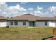 Home exterior showing a flat backyard with fresh green grass and a sliding glass door at 2958 Flying Blackbird Rd, Bartow, FL 33830
