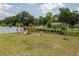 Fenced backyard featuring green grass and an installed playset with a slide and swings at 2958 Flying Blackbird Rd, Bartow, FL 33830