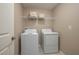 Bright laundry room with white washer and dryer and storage shelves at 2958 Flying Blackbird Rd, Bartow, FL 33830