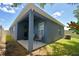 The covered patio has two chairs, a door, and a window, with a green lawn surrounding it at 312 Walnut Ln, Auburndale, FL 33823