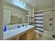 Bathroom with vanity and shower featuring blue and white striped curtains at 312 Walnut Ln, Auburndale, FL 33823