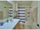 Bathroom with vanity and shower featuring blue and white striped curtains at 312 Walnut Ln, Auburndale, FL 33823