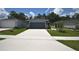 Single-story home with well-maintained lawn and driveway leading to the attached two-car garage at 312 Walnut Ln, Auburndale, FL 33823